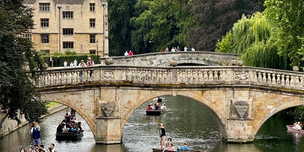 Classic scene of a punt on the River Cam passing the Backs and Bridge of Sighs