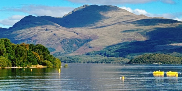 Loch Lomond blue waters dotted with islands and mountain reflections