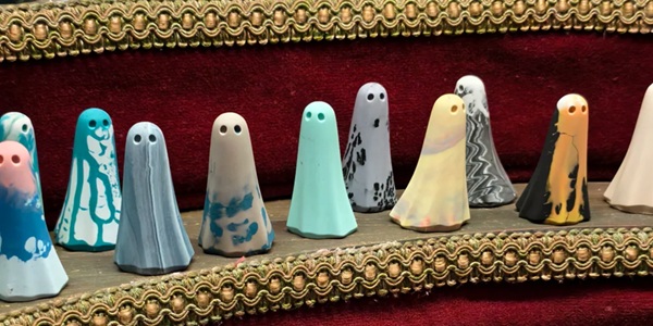 The York Ghost Merchants Candlelit Window Display with Handmade Terracotta Ghosts on the Wall